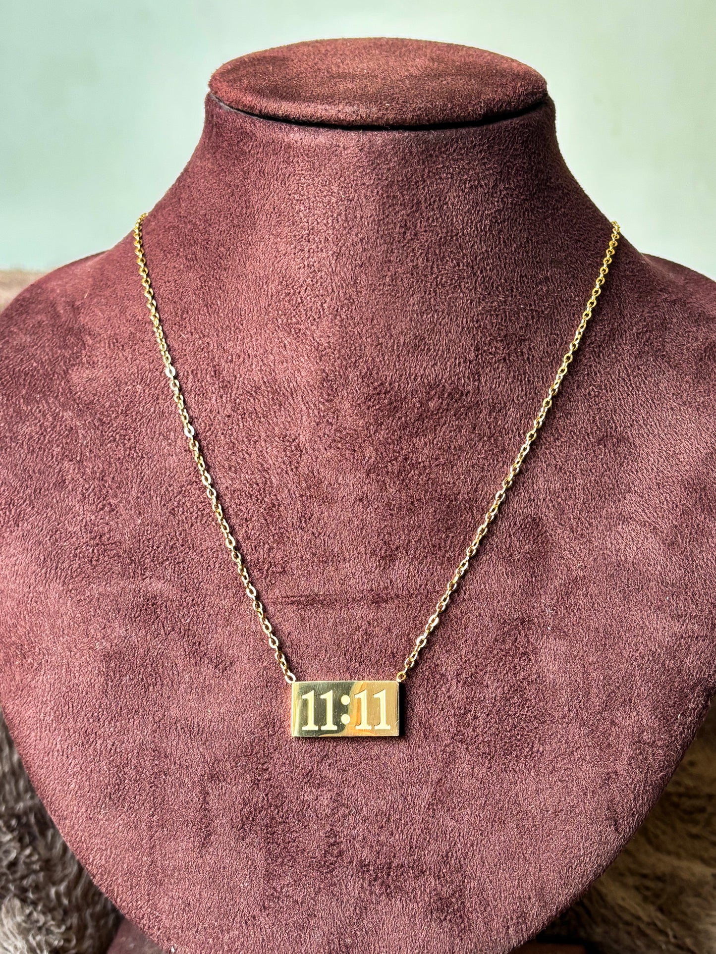 Gold 11:11 manifestation necklace with a rectangular engraved pendant on a delicate gold chain. Minimalist everyday jewelry symbolizing positivity, wishes and new beginnings. 