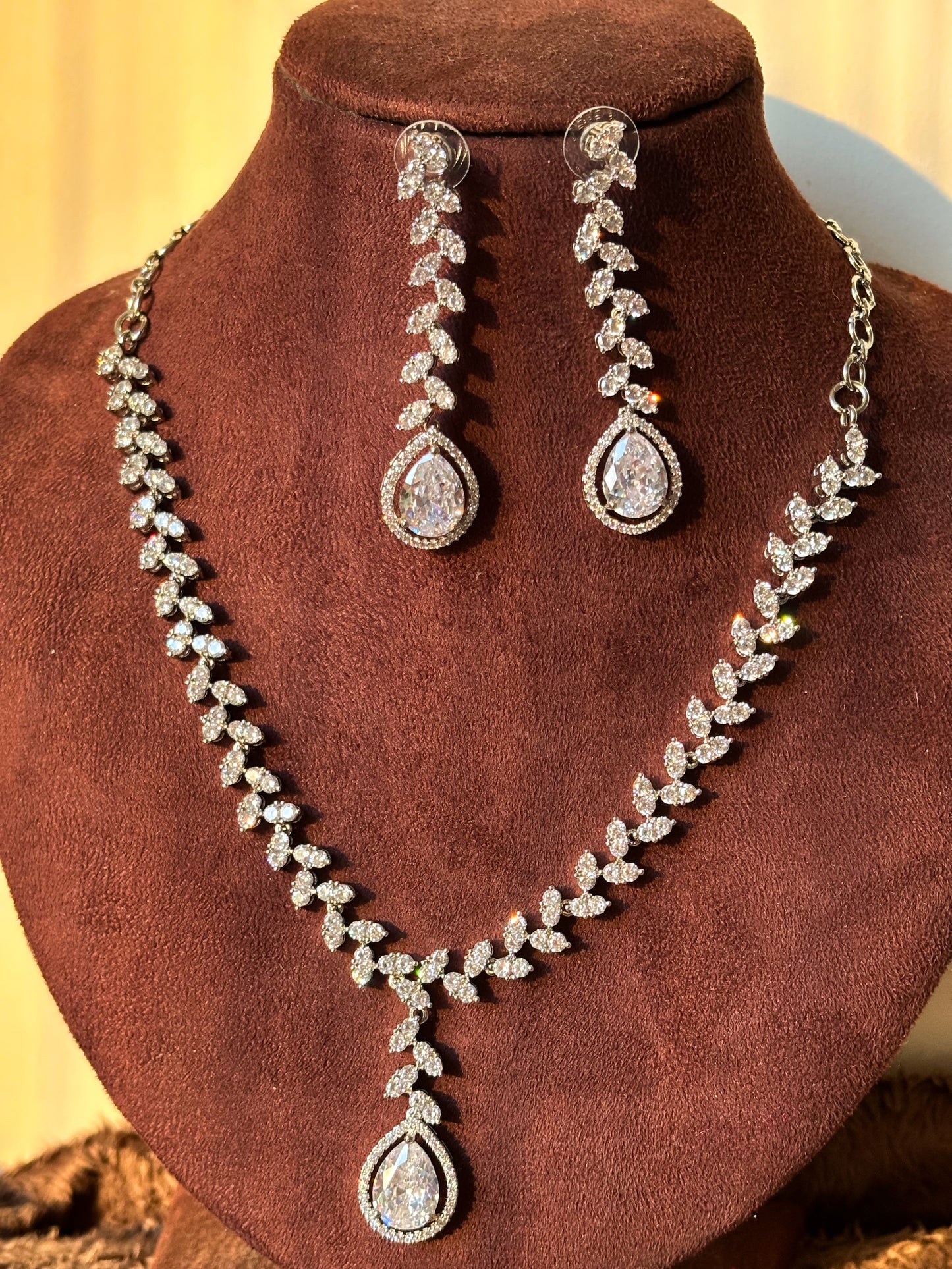 Shop our premium American Diamond necklace set. Featuring a stunning pear cut pendant and vine style earrings. It's the perfect jewellery for weddings and parties. High - quality CZ stones with a long - lasting silver finish.