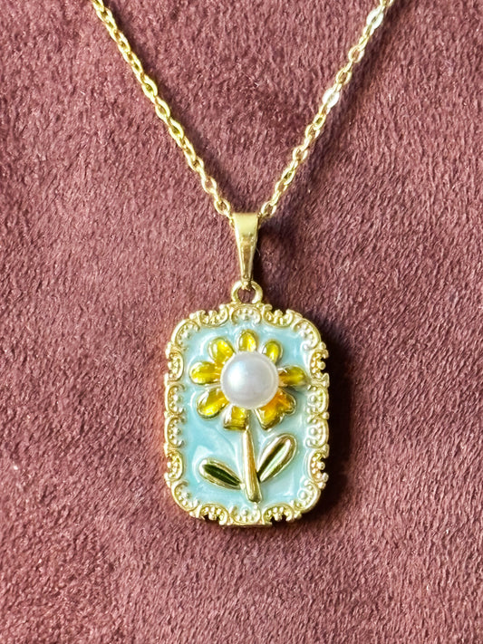 Necklace with a pendant featuring a sunflower design on a baby blue background with pearl