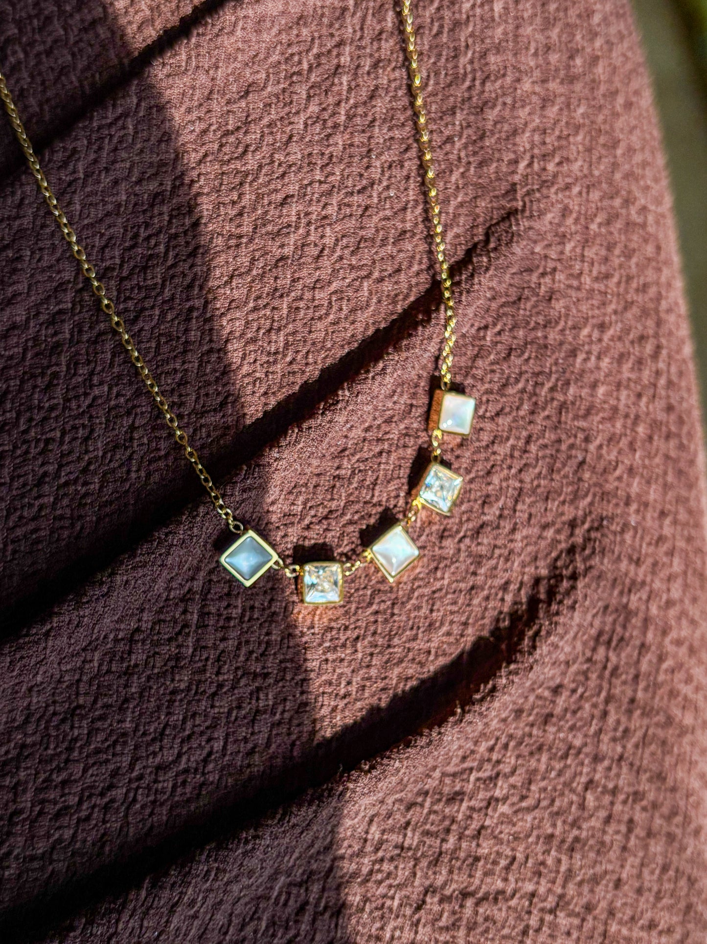 Dainty gold necklace with square gemstone charms in a minimalist anti-tarnish design