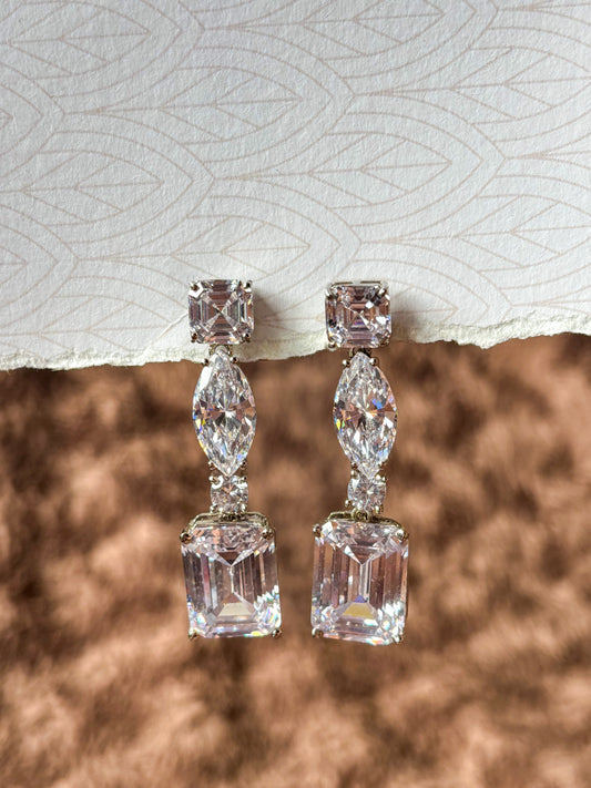 Elegant AD drop earrings with emerald-cut and marquise-shaped stones. Sparkling silver-tone statement earrings perfect for weddings, festive wear and party looks.