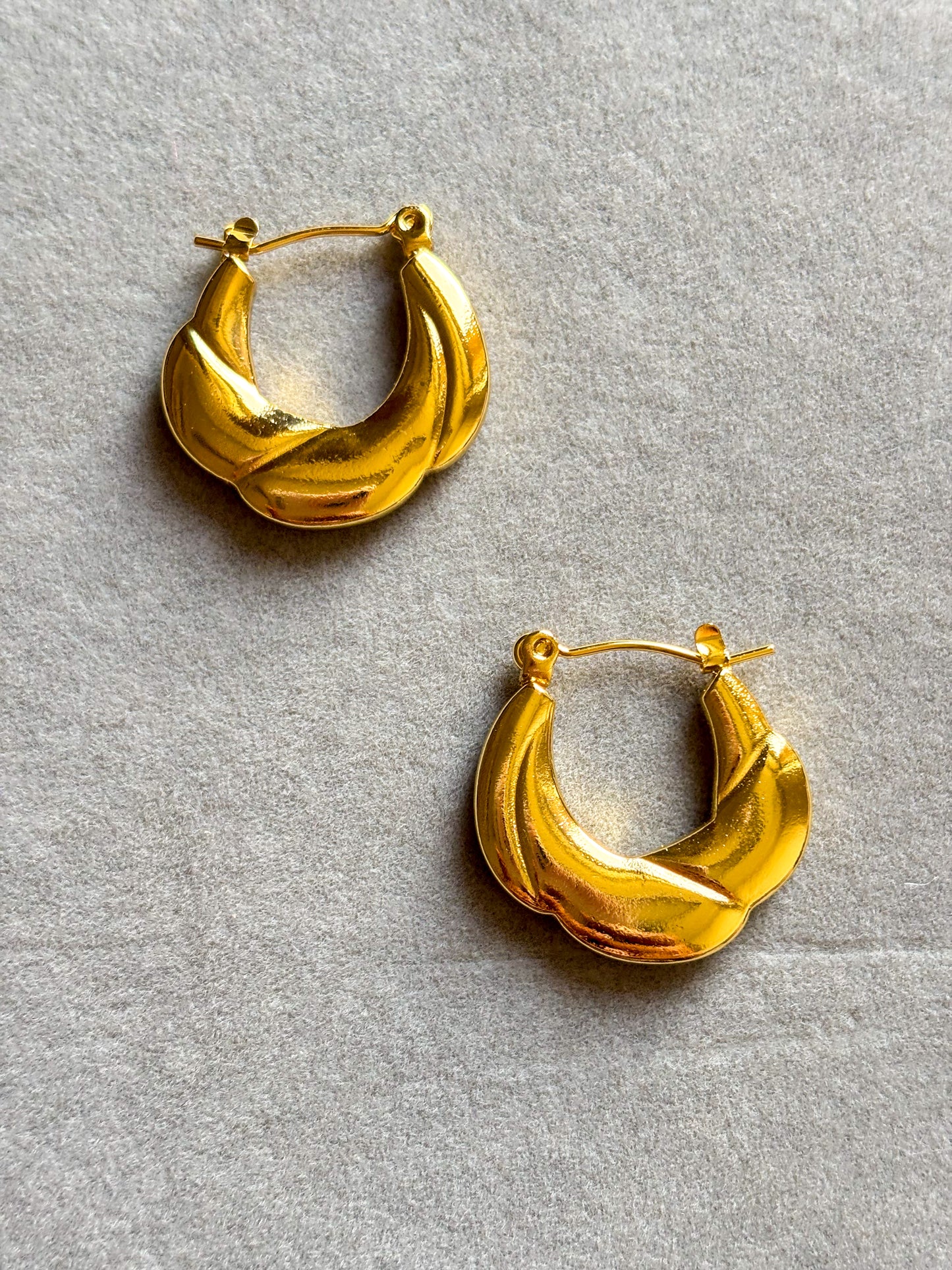 Anti-tarnish sculpted gold hoop earrings with a bold textured design, displayed with natural lighting for a luxurious, minimalist look.