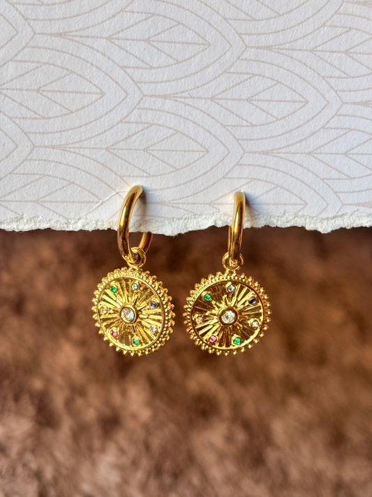 Elegant gold hoop earrings featuring celestial-inspired pendants and multicolor stones.