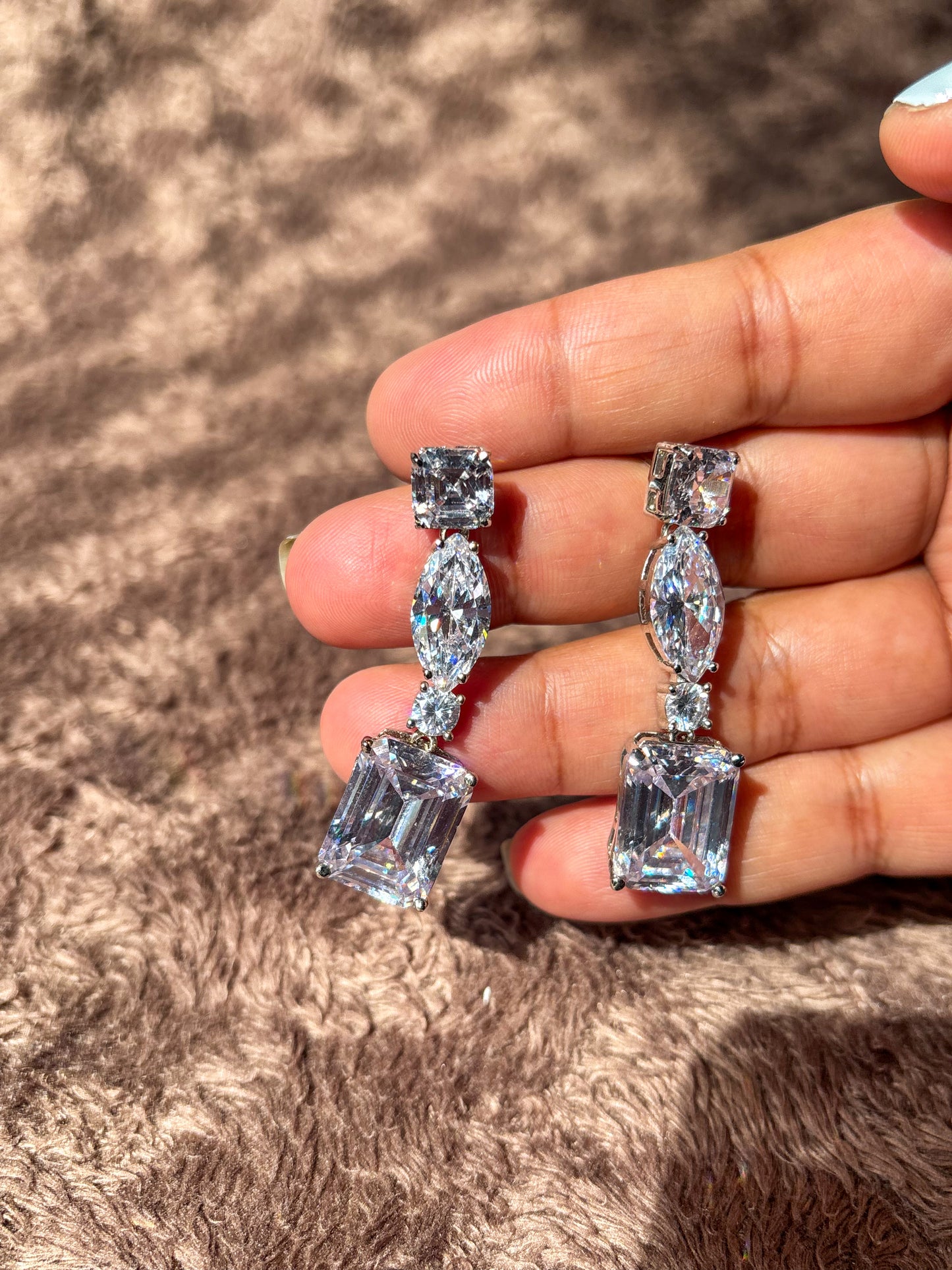 Elegant AD drop earrings with emerald-cut and marquise-shaped stones. Sparkling silver-tone statement earrings perfect for weddings, festive wear and party looks.