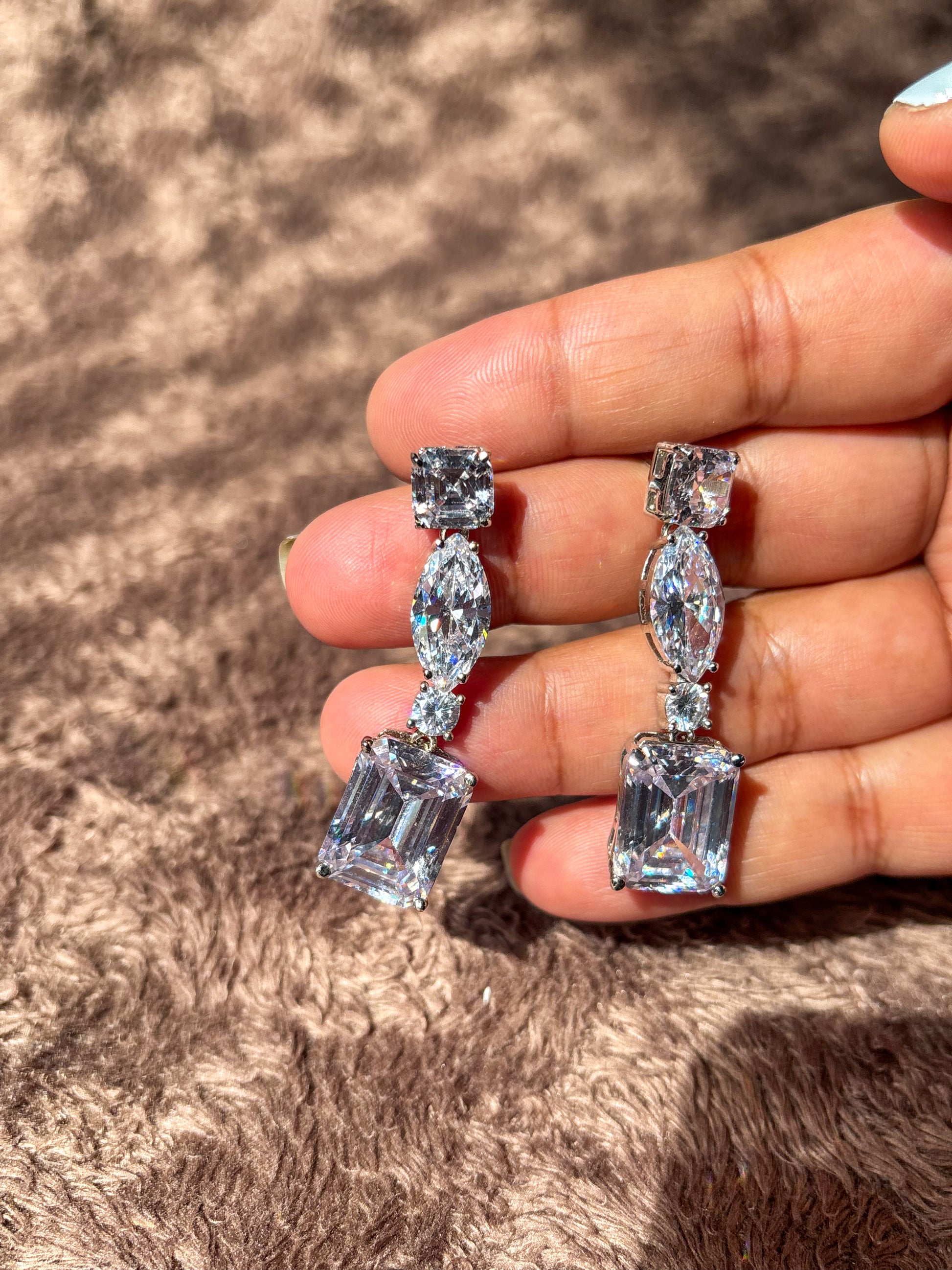 Elegant AD drop earrings with emerald-cut and marquise-shaped stones. Sparkling silver-tone statement earrings perfect for weddings, festive wear and party looks.
