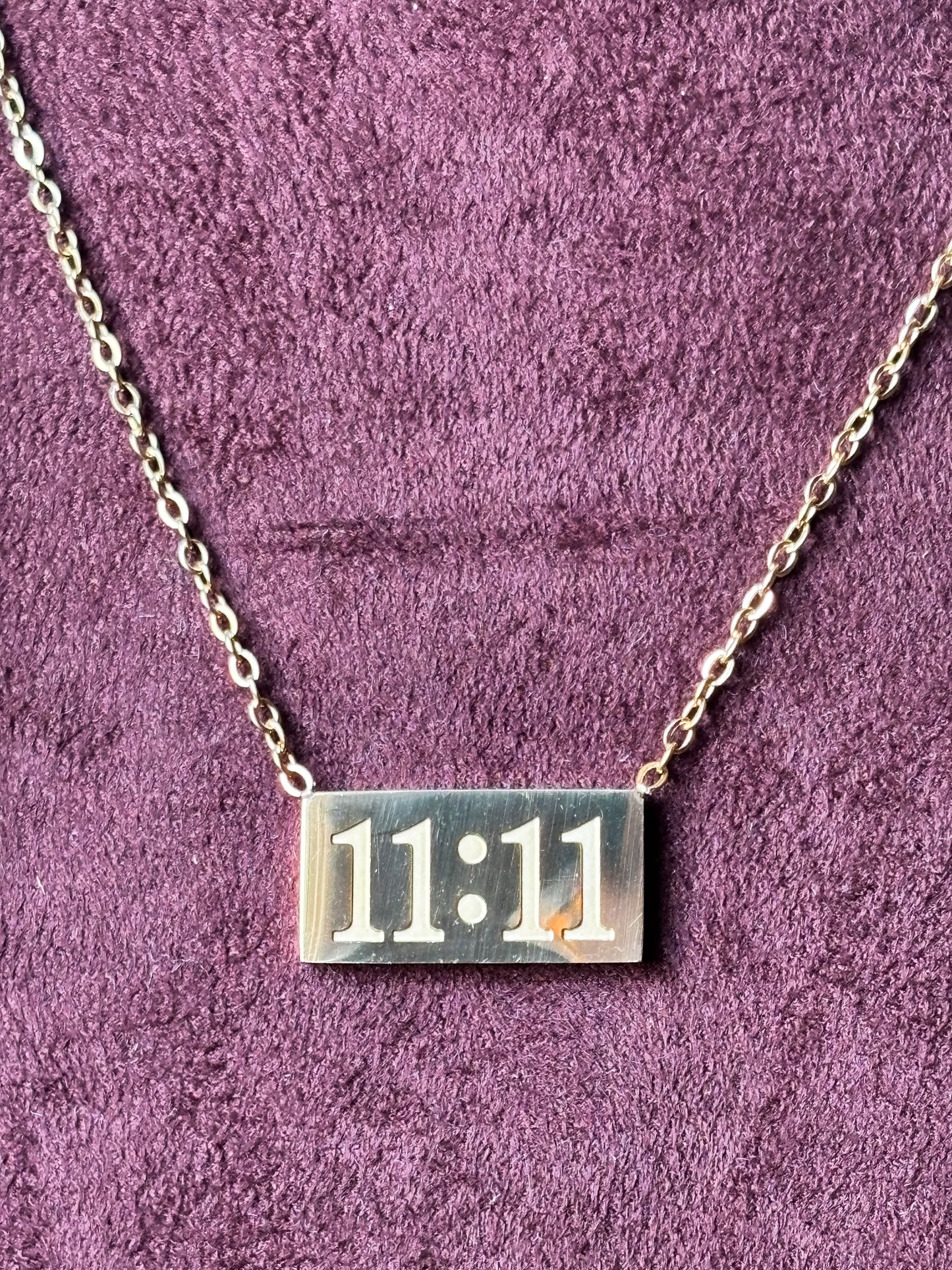 Gold 11:11 manifestation necklace with a rectangular engraved pendant on a delicate gold chain. Minimalist everyday jewelry symbolizing positivity, wishes and new beginnings. 