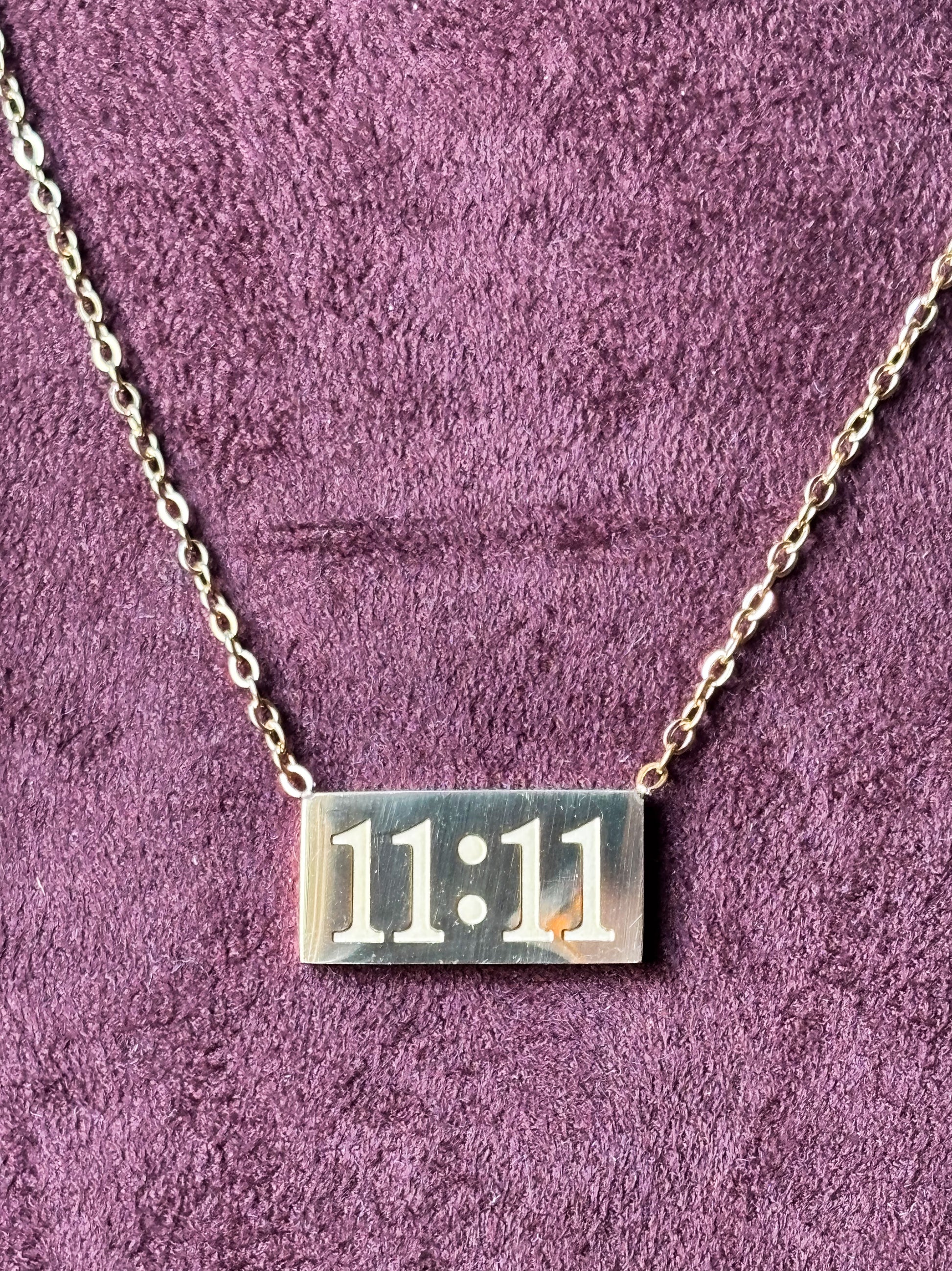 Gold 11:11 manifestation necklace with a rectangular engraved pendant on a delicate gold chain. Minimalist everyday jewelry symbolizing positivity, wishes and new beginnings. 