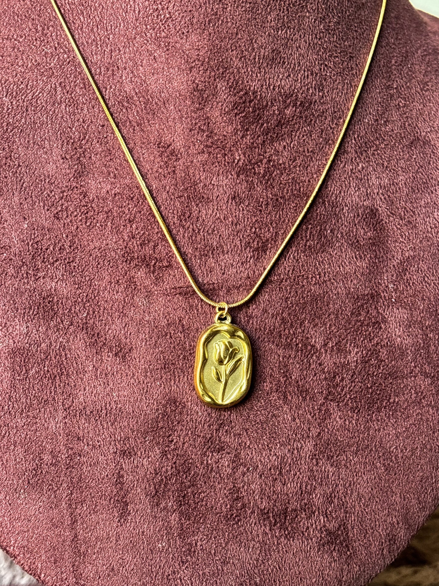 Elegant anti-tarnish gold-tone rose pendant necklace featuring a floral engraved rectangular charm on a sleek snake chain.Perfect for everyday wear, gifting, and minimalist jewellery styling.