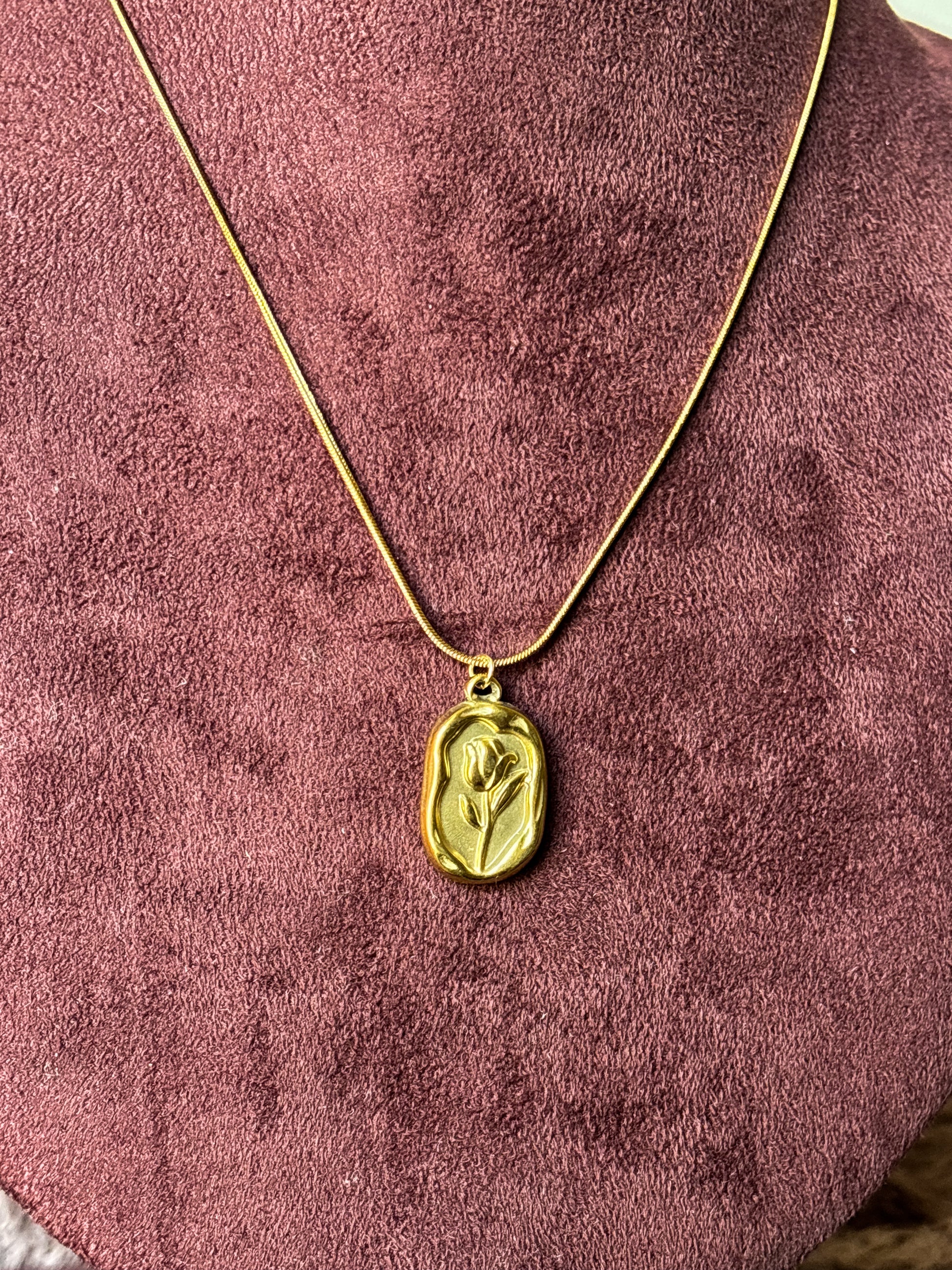 Elegant anti-tarnish gold-tone rose pendant necklace featuring a floral engraved rectangular charm on a sleek snake chain.Perfect for everyday wear, gifting, and minimalist jewellery styling.