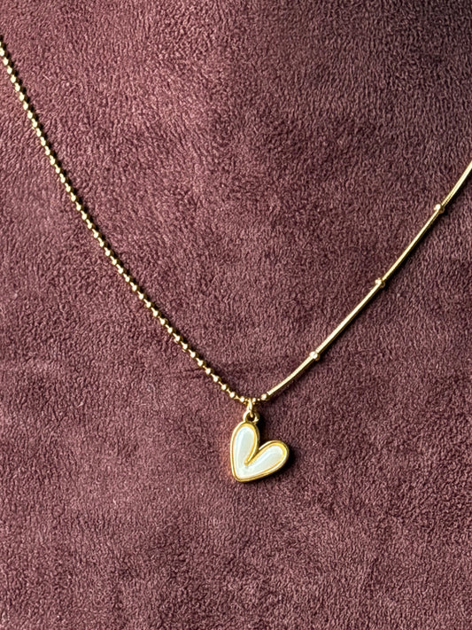 Gold-tone dual-chain necklace featuring a delicate ball chain and snake chain design with a white enamel heart pendant. Perfect minimalist jewellery for everyday wear.