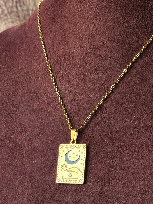 Gold necklace with a rectangular pendant featuring a moon and star design.