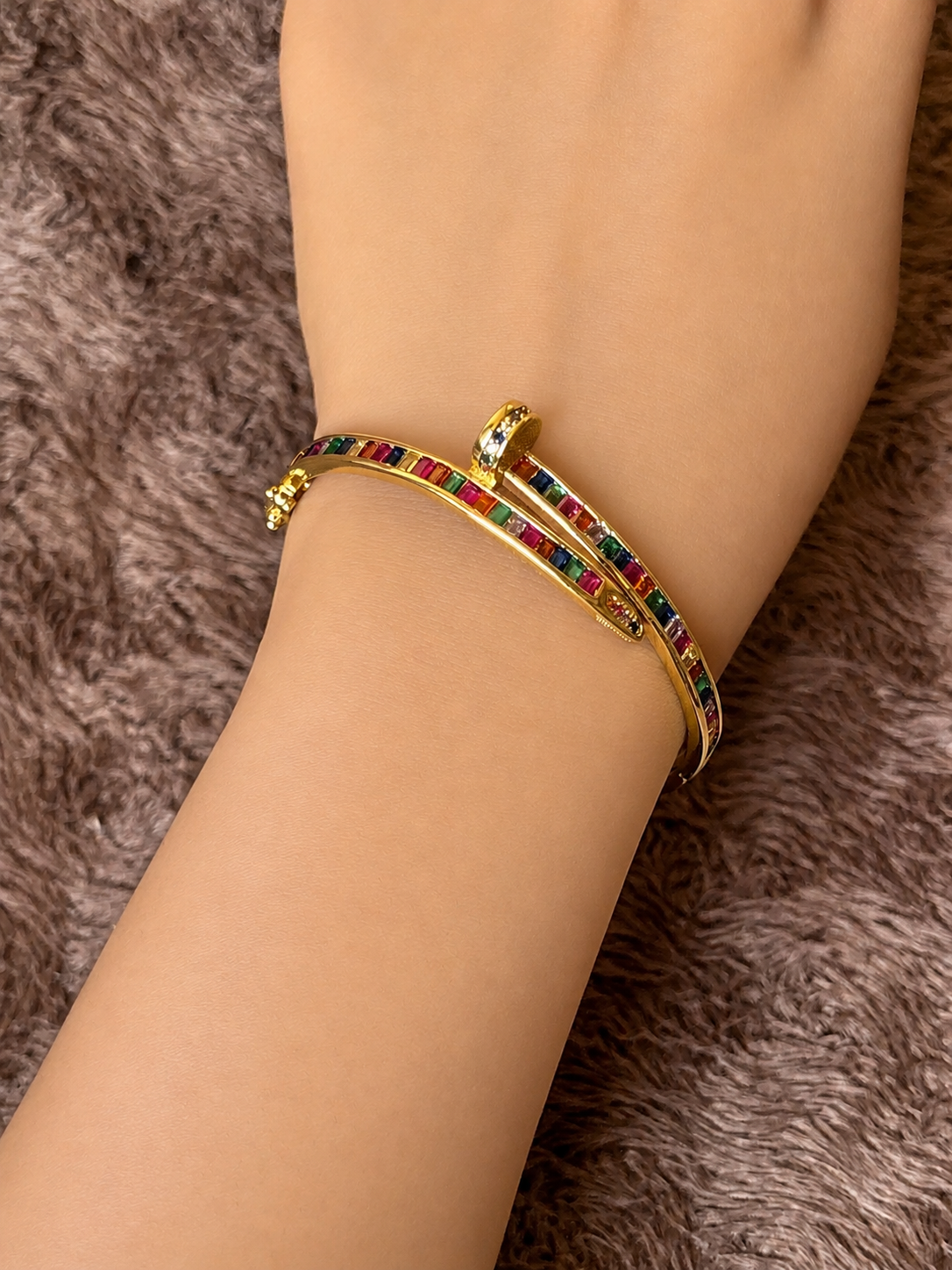 Gold-tone anti-tarnish nail bracelet featuring vibrant multicolor baguette-cut stones in a sleek open cuff design. A trendy statement bracelet perfect for everyday wear, stacking and gifting.